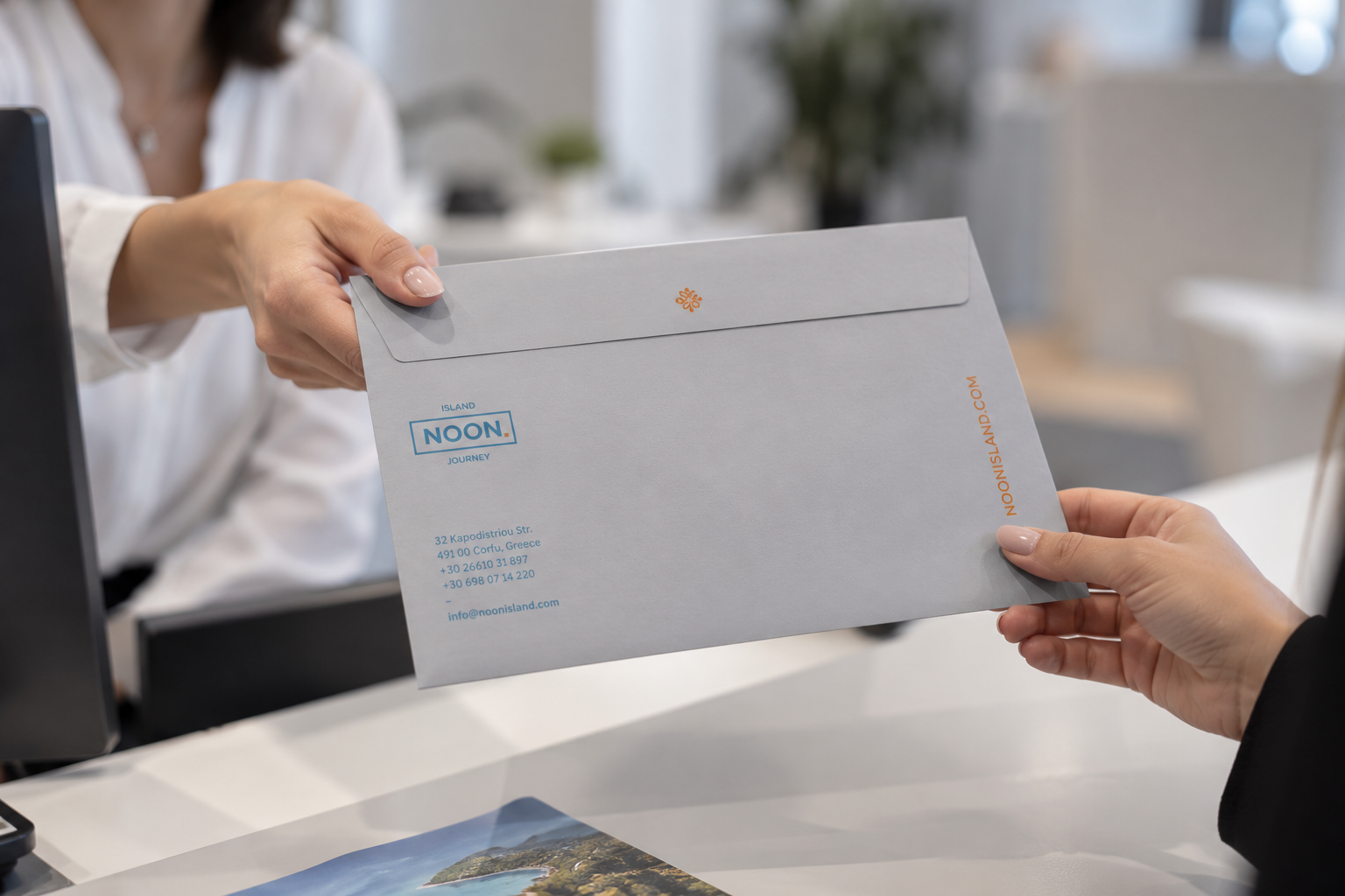 Noon Island Journey document folder handed over at a travel office — corporate identity by Poua Design