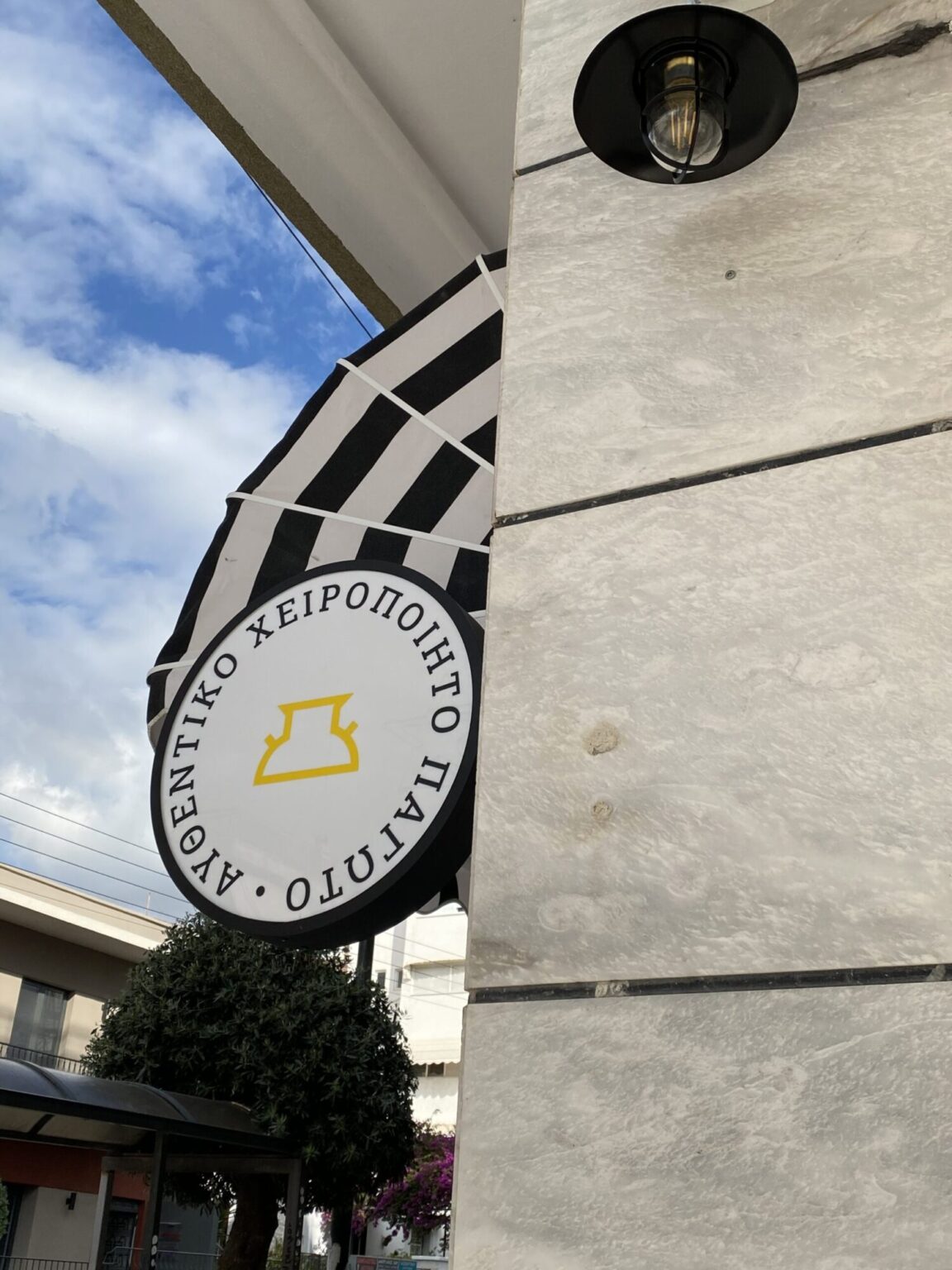Hanging Tyrakeion sign on the shop façade — Poua Design