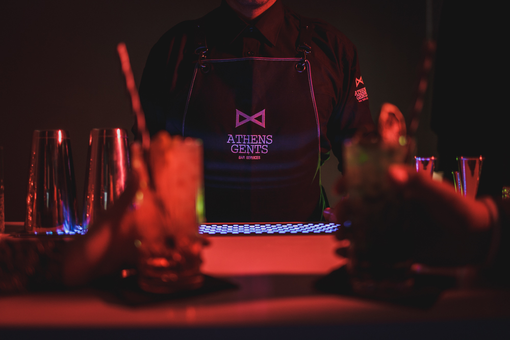 Athens Gents bar with illuminated logo at an evening event — Poua Design