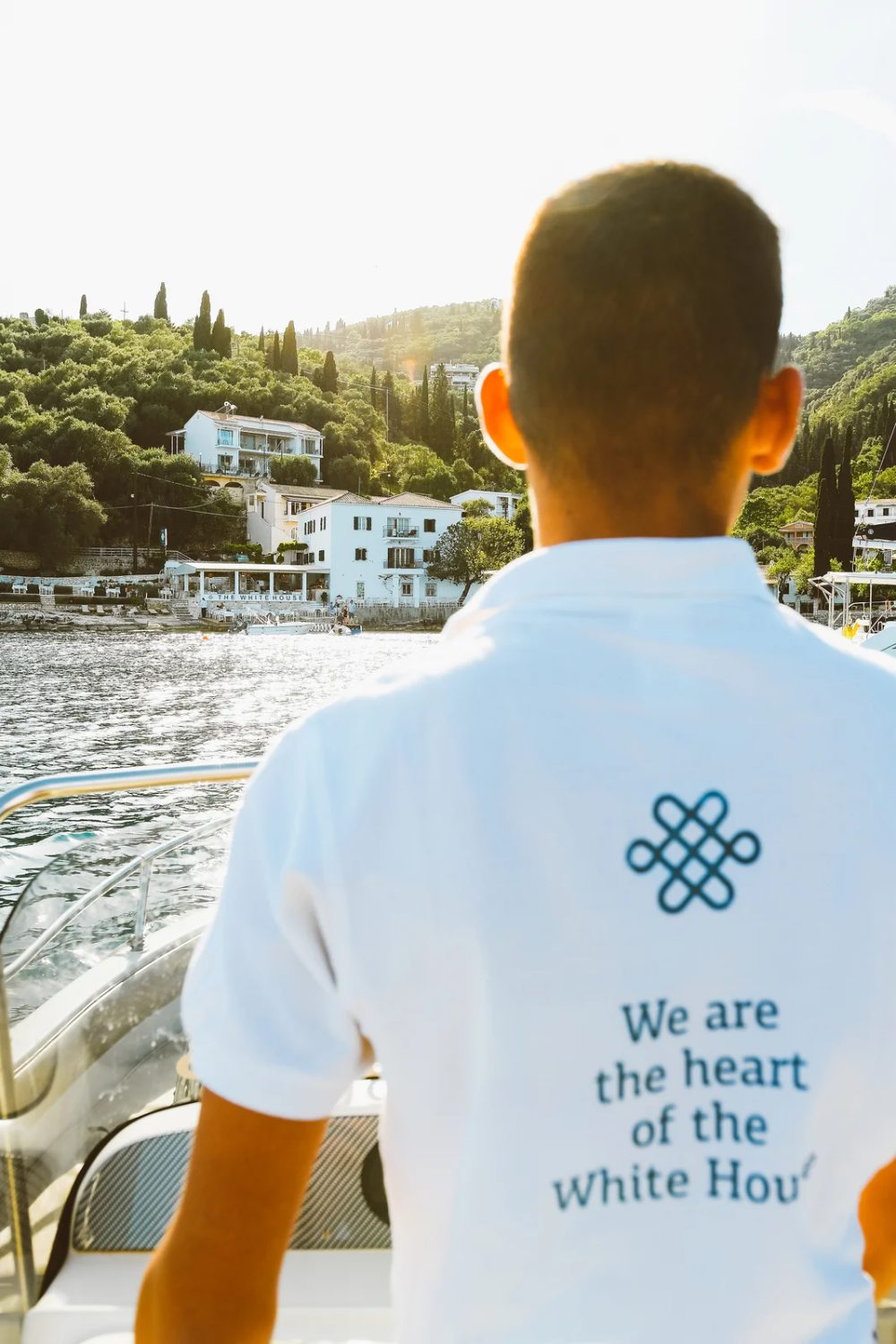 Staff member in a white polo shirt with The White House knot symbol and the line We are the heart of the White House, uniform design by Poua Design